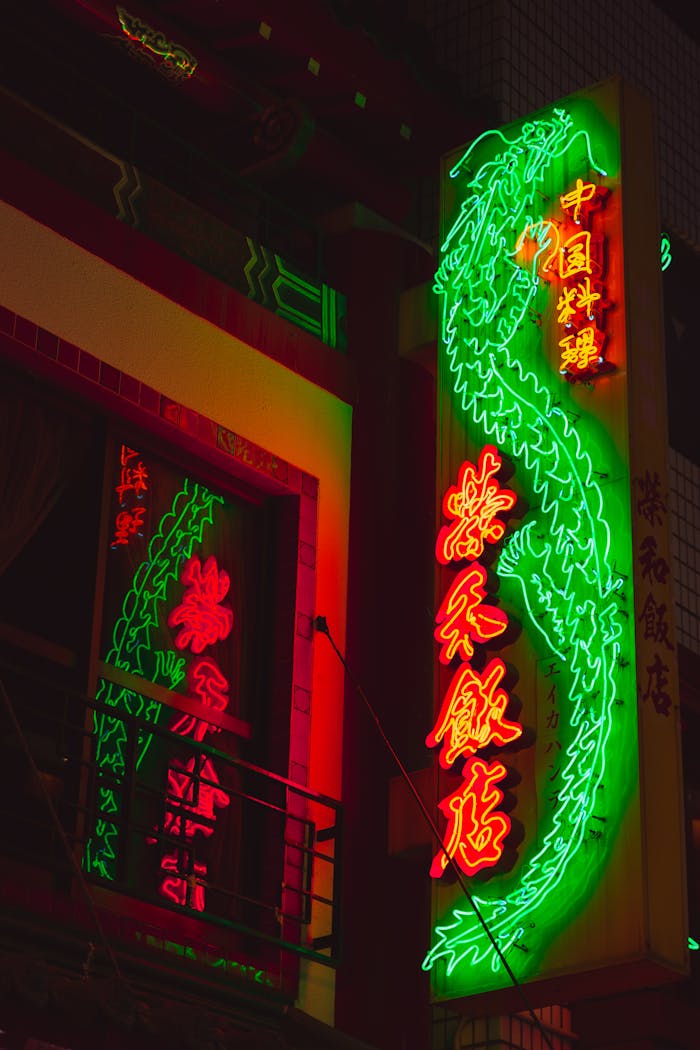 From below of illuminated sign with bright Chinese hieroglyphs hanging outside building at night